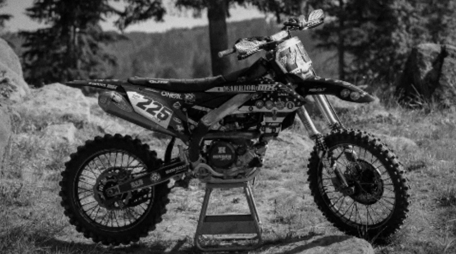 The #225 Warrior MX tribute bike on a stand in the mountains